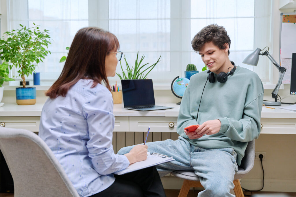 Young Man sitting with a Clinician answering questions as part of an assessment